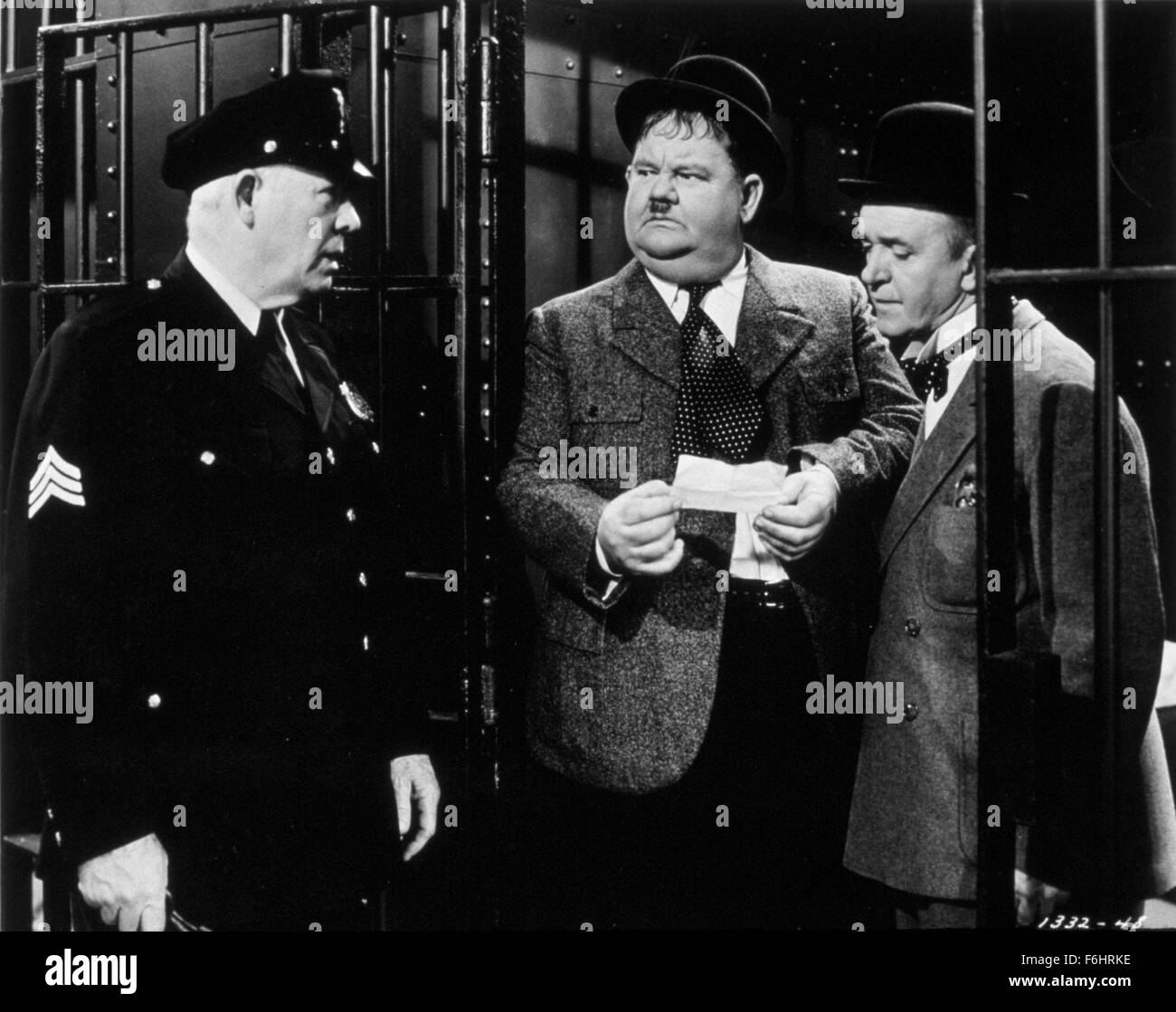 1944, Film Title: NOTHING BUT TROUBLE, Director: SAM TAYLOR, Studio: MGM, Pictured: 1944, BEHIND BARS (IN JAIL), OLIVER HARDY, LAUREL & HARDY, STAN LAUREL, SAM TAYLOR, GAOL, PRISON, FAT, SWEATY, HITLER MOUSTACHE, WARDEN, COMEDY, HAT. (Credit Image: SNAP) Stock Photo