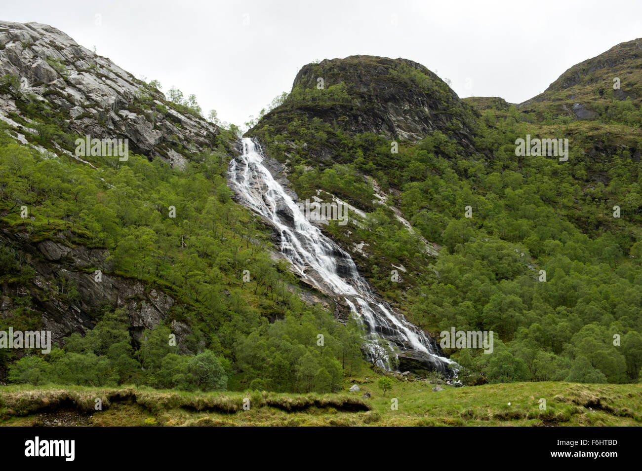 The majestic waterfalls at Steall tumbling into the water of Nevis deep in Glen Nevis Stock Photo