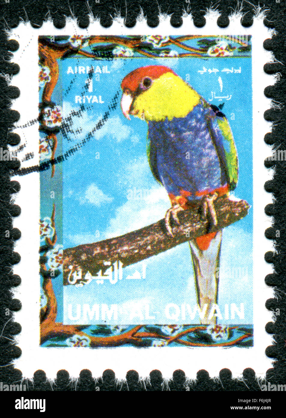 Postage stamp printed in Umm al-Quwain, show bird Red-capped Parrot (Purpureicephalus spurius) Stock Photo