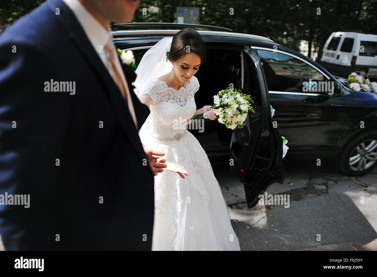 groom take hand his bride out from wedding car Stock Photo - Alamy