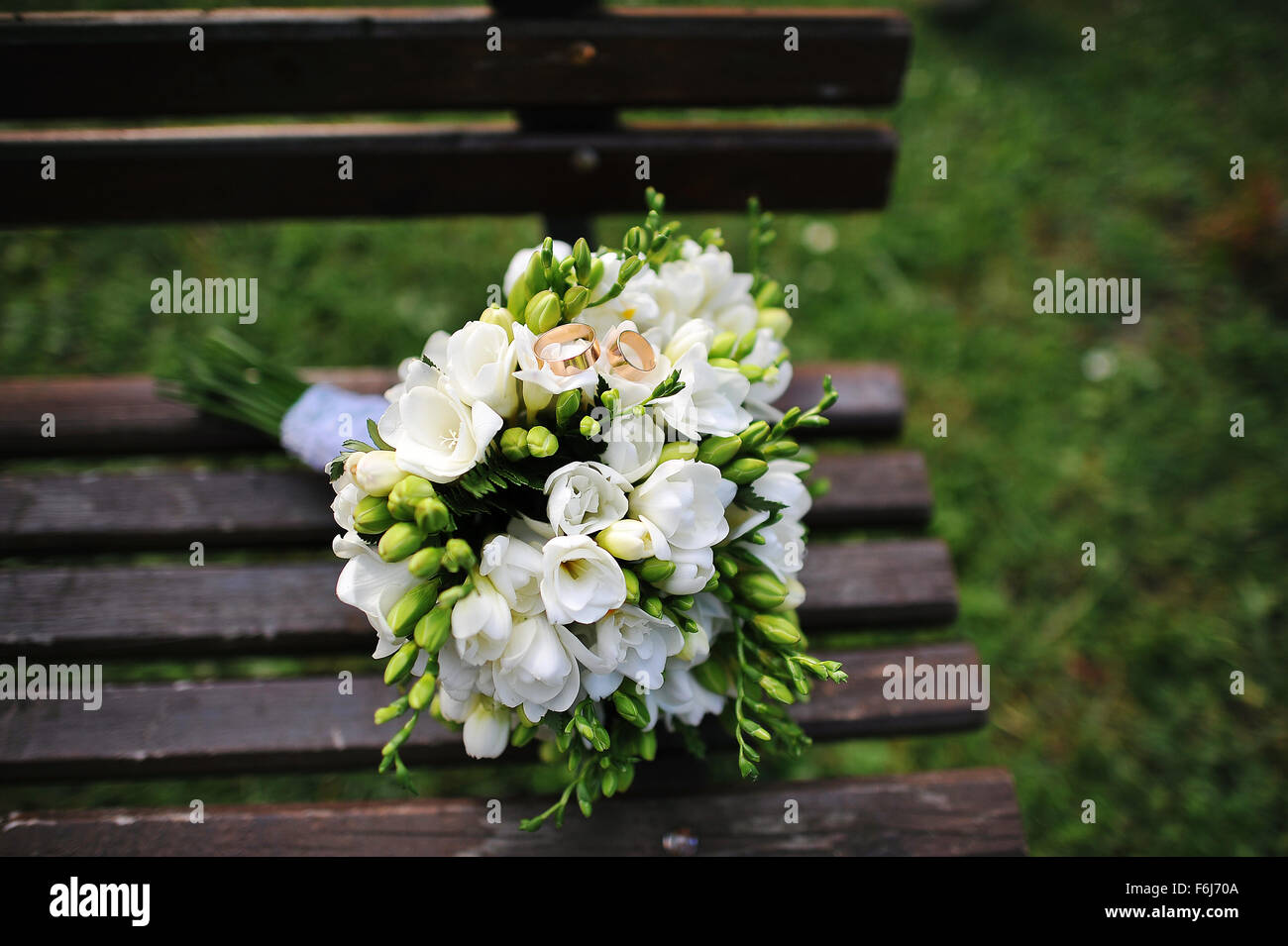wedding bouquet with rings on wooden bench Stock Photo Alamy