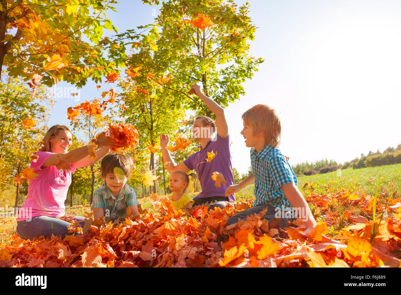 Parents and kids throw leaves in the air together Stock Photo Alamy