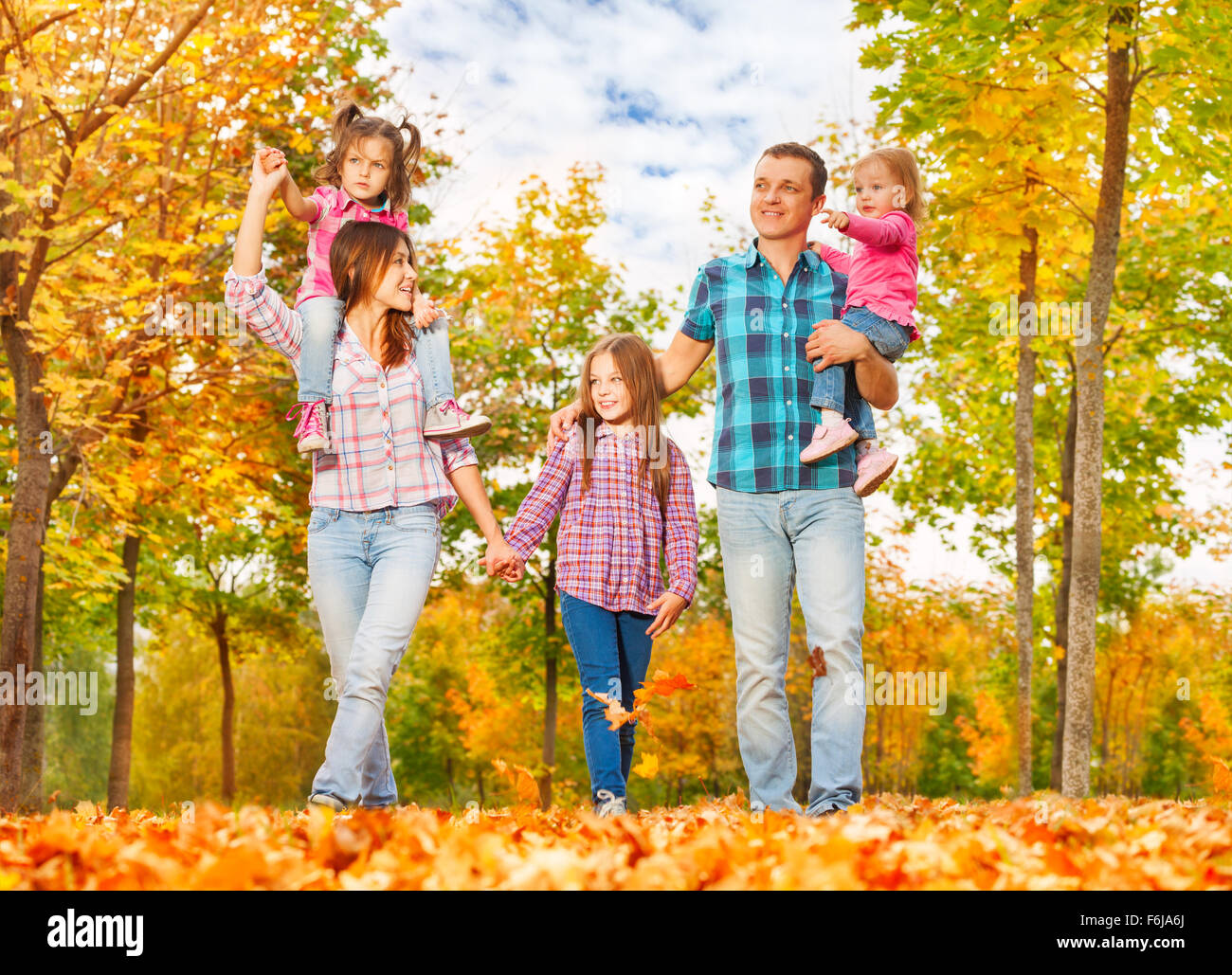 Family walk in the autumn park holding hands Stock Photo