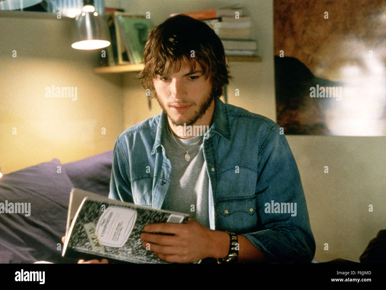 RELEASE DATE: January 23, 2004. MOVIE TITLE: The Butterfly Effect. STUDIO: BenderSpink. PLOT: A young man blocks out harmful memories of significant events of his life. As he grows up, he finds a way to remember these lost memories and a supernatural way to alter his life. PICTURED: ASHTON KUTCHER holds a book as Evan Treborn. Stock Photo