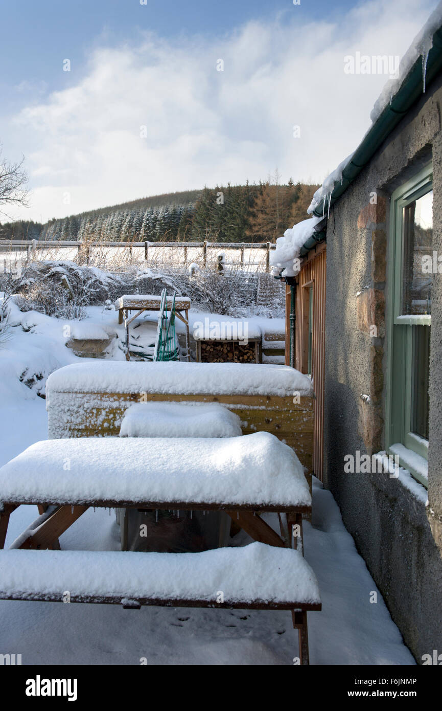 snow built up on an outside picnic bench in a domestic garden in aberdeenshire Stock Photo