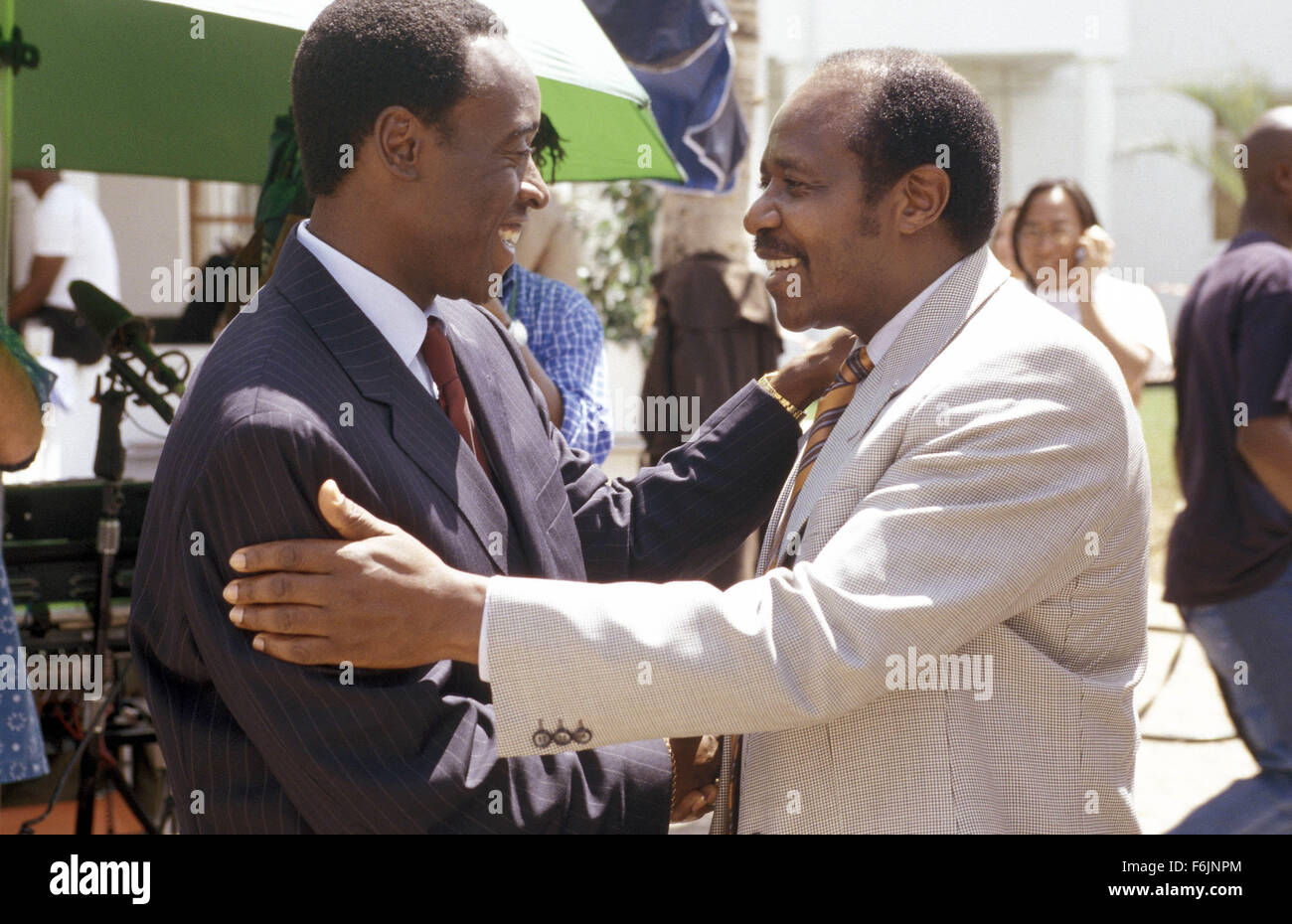 RELEASE DATE: February 4, 2005. MOVIE TITLE: Hotel Rwanda. STUDIO: United Artists. PLOT: The true-life story of Paul Rusesabagina, a hotel manager who housed over a thousand Tutsi refugees during their struggle against the Hutu militia in Rwanda. PICTURED: DON CHEADLE greets PAUL RUSESABAGINA on the set. Stock Photo