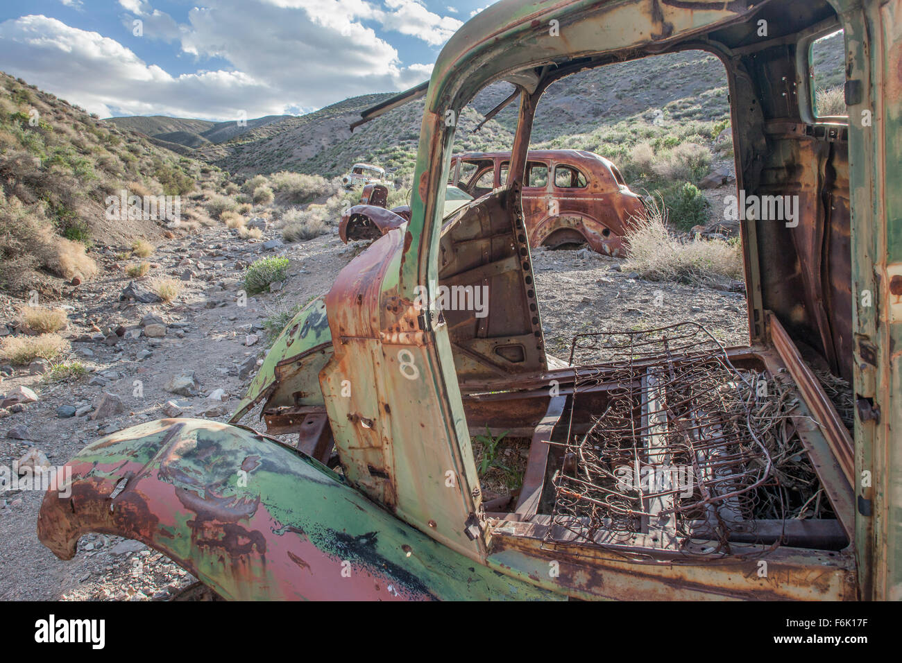 Vintage cars rusting away in a dry wash in Death Valley, California, USA. Stock Photo