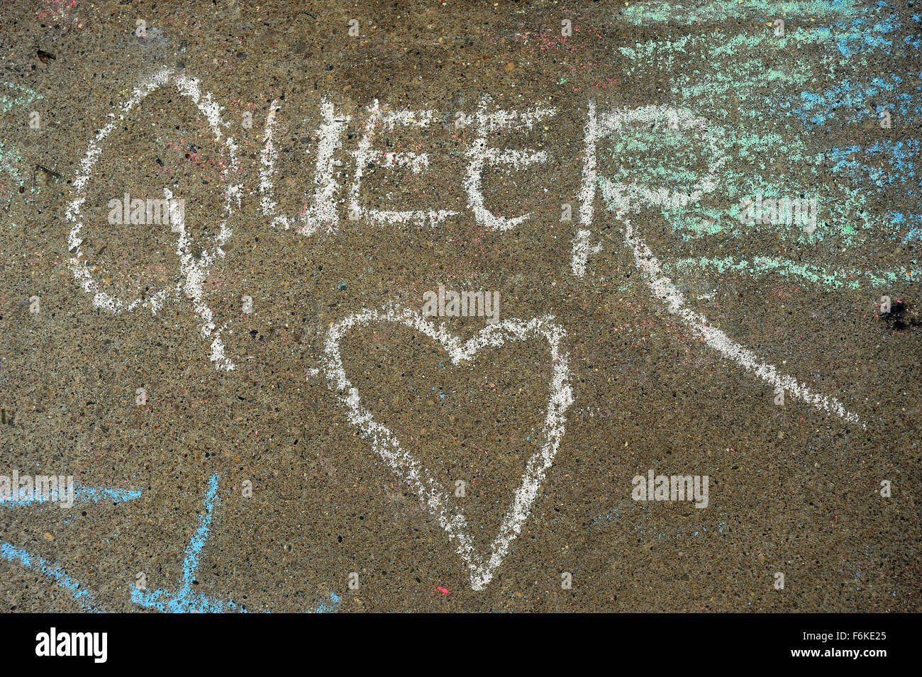 The word Queer and a heart written on the ground in chalk at London, Ontario pride. Stock Photo