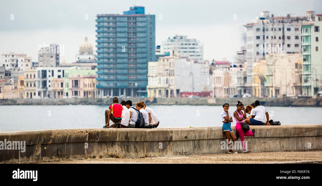 Teens Cubans to laying bricks of the Malecon, Havana in the background, Street Scene, La Habana, Cuba, Caribbean, North America Stock Photo