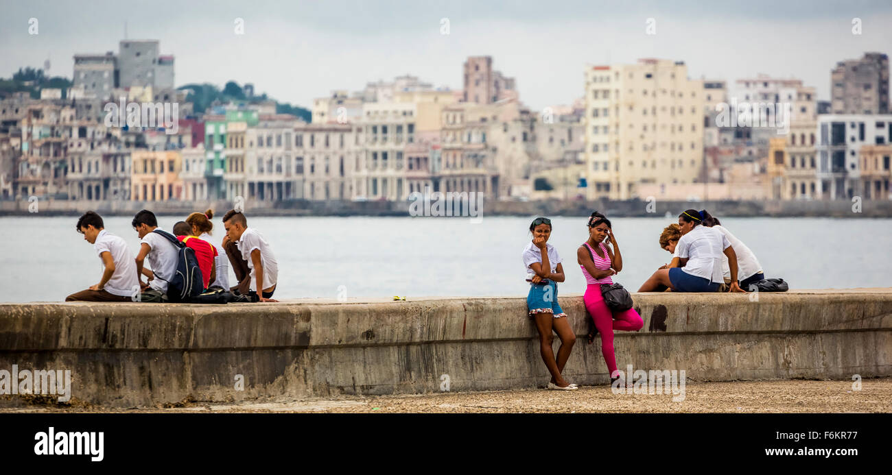 Teens Cubans to laying bricks of the Malecon, Havana in the background, Street Scene, La Habana, Cuba, Caribbean, North America, Stock Photo