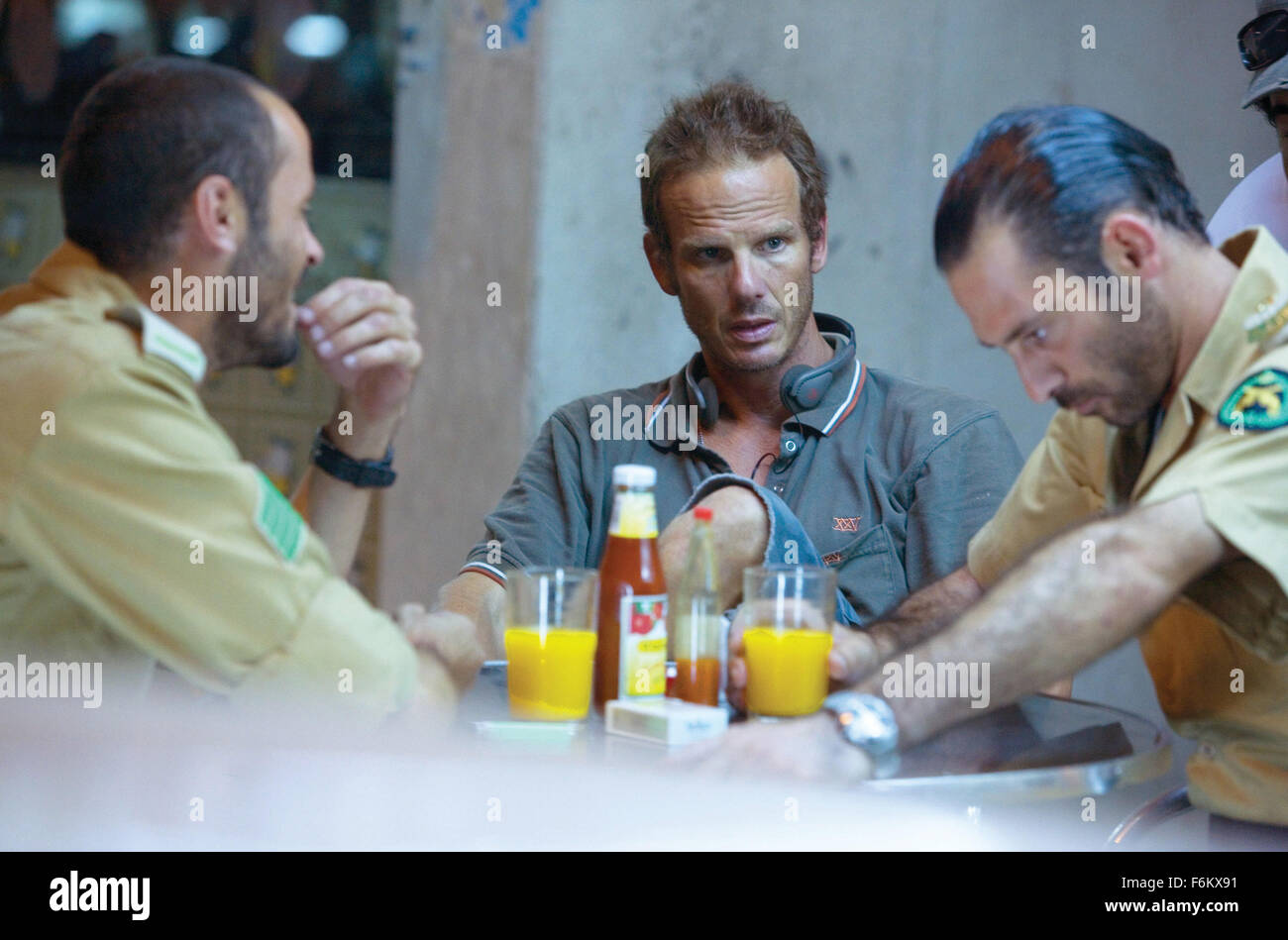 RELEASE DATE: September 28, 2007. MOVIE TITLE: The Kingdom - STUDIO: Universal Pictures. PLOT: A team of U.S. government agents is sent to investigate the bombing of an American facility in the Middle East. PICTURED: (L-R) ALI SULIMAN as Saudi Sergeant Haytham, director PETER BERG and ASHRAF BARHOM as Saudi Colonel Al Ghazi on the set. Stock Photo