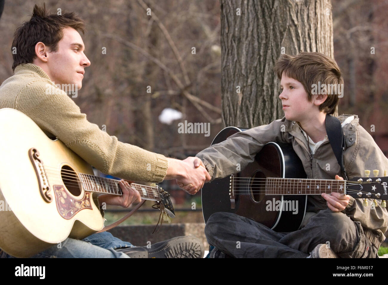 RELEASE DATE: Oct 21, 2007. MOVIE TITLE: August Rush. STUDIO: CJ Entertainment. PLOT: The story of a charismatic young Irish guitarist and a sheltered young cellist who have a chance encounter one magical night above New York's Washington Square, but are soon torn apart, leaving in their wake an infant, August Rush, orphaned by circumstance. Now performing on the streets of New York and cared for by a mysterious stranger, August uses his remarkable musical talent to seek the parents from whom he was separated at birth. PICTURED: JONATHAN RHYS MEYERS as Louis Connelly, and FREDDIE HIGHMORE as E Stock Photo