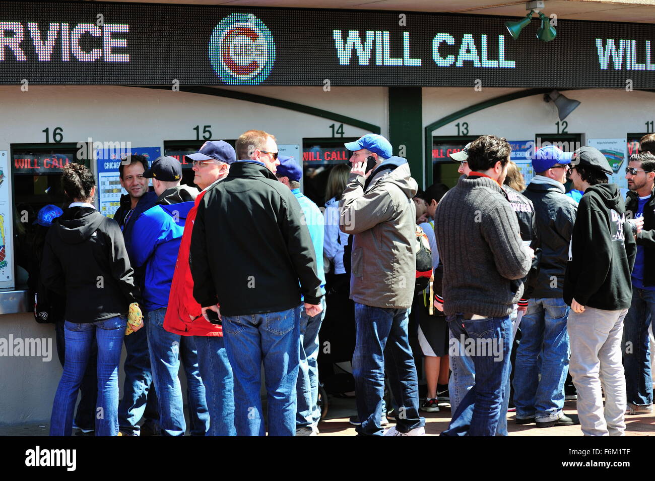 Fans line up to buy or pick up tickets to enter iconic Wrigley Field, home to the Chicago Cubs prior to a baseball game. Chicago, Illinois, USA. Stock Photo