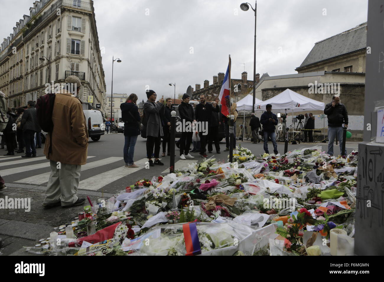 Paris, France. 17th Nov, 2015. People pay their respects at the memorial outside the restaurant Le Petit Cambodge for the people killed here during the Paris attacks. Parisians and tourists continue to visit the memorials for the people killed in the terrorists attacks in Paris, to lay down flowers and candles and to pay their respect. Over 130 people have been by terrorist from the Islamic State. Credit:  Michael Debets/Pacific Press/Alamy Live News Stock Photo