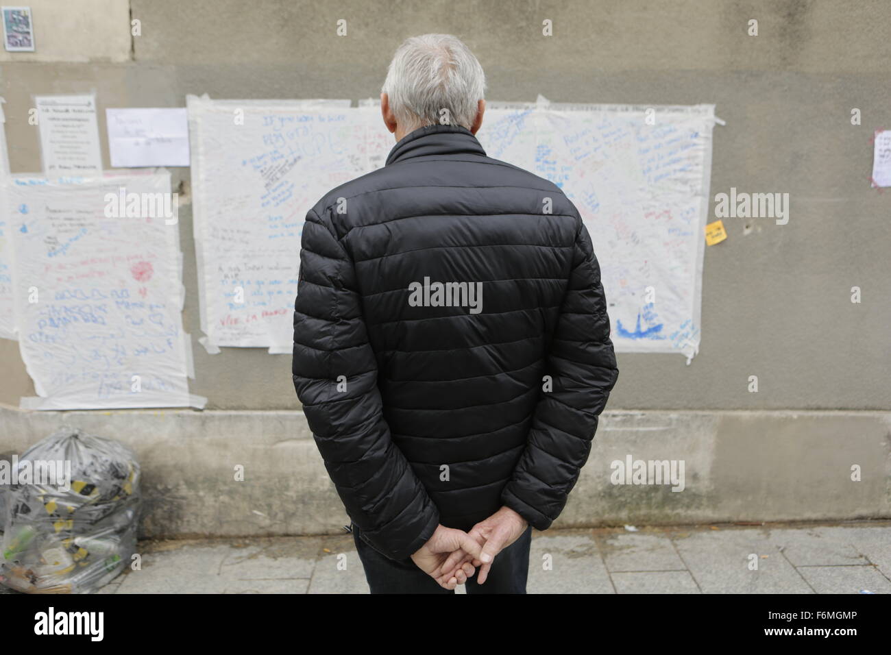 Paris, France. 17th Nov, 2015. A man reads the wall of messages that has been created opposite the cafe and bar Le Carillon and the restaurant Le Petit Cambodge, to sites of the Paris attacks. Parisians and tourists continue to visit the memorials for the people killed in the terrorists attacks in Paris, to lay down flowers and candles and to pay their respect. Over 130 people have been by terrorist from the Islamic State. Credit:  Michael Debets/Pacific Press/Alamy Live News Stock Photo