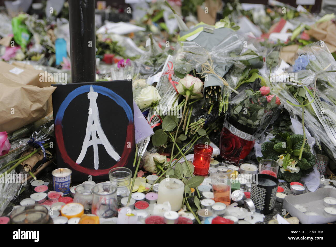 Paris, France. 17th Nov, 2015. A painted peace sign with the Eiffel Tower in it has been placed at the memorial outside the restaurant Le Petit Cambodge for the people killed here during the Paris attacks. Parisians and tourists continue to visit the memorials for the people killed in the terrorists attacks in Paris, to lay down flowers and candles and to pay their respect. Over 130 people have been by terrorist from the Islamic State. Credit:  Michael Debets/Pacific Press/Alamy Live News Stock Photo