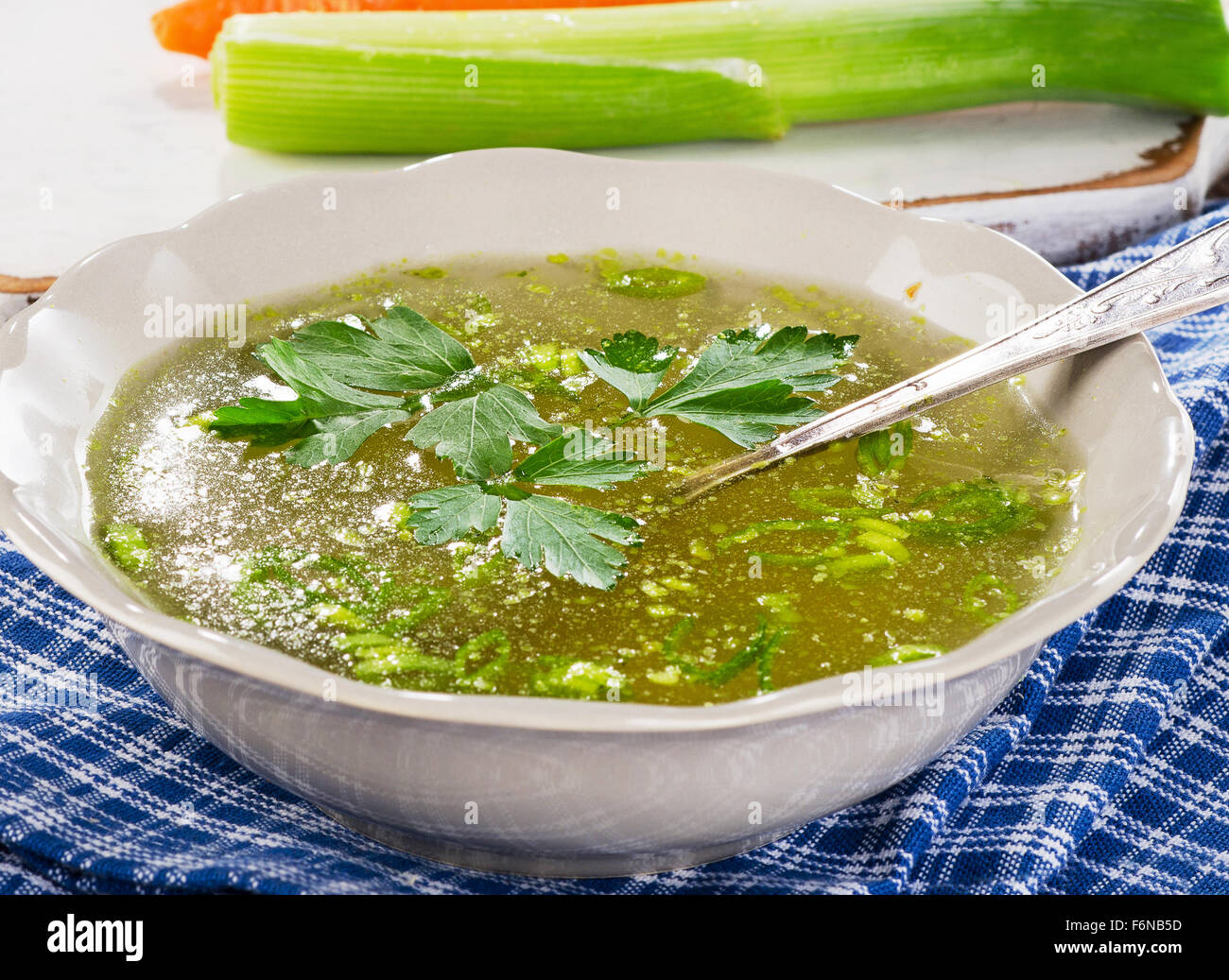 Broth with parsley in bowl  on a wooden table. Selective focus Stock Photo