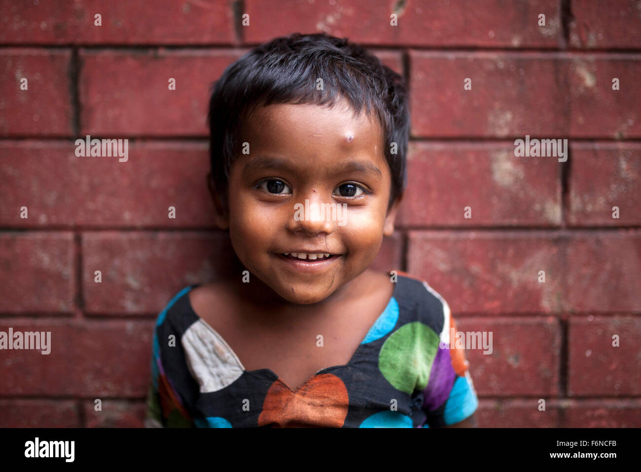 DHAKA, BANGLADESH 17th November: Portrait of a street child in front of old building in Old Dhaka on November 17, 2015. Old Dhaka is a term used to refer to the historic old city of Dhaka, the capital of modern Bangladesh. It was founded in 1608 as Jahangir Nagar, the capital of Mughal Bengal. Stock Photo