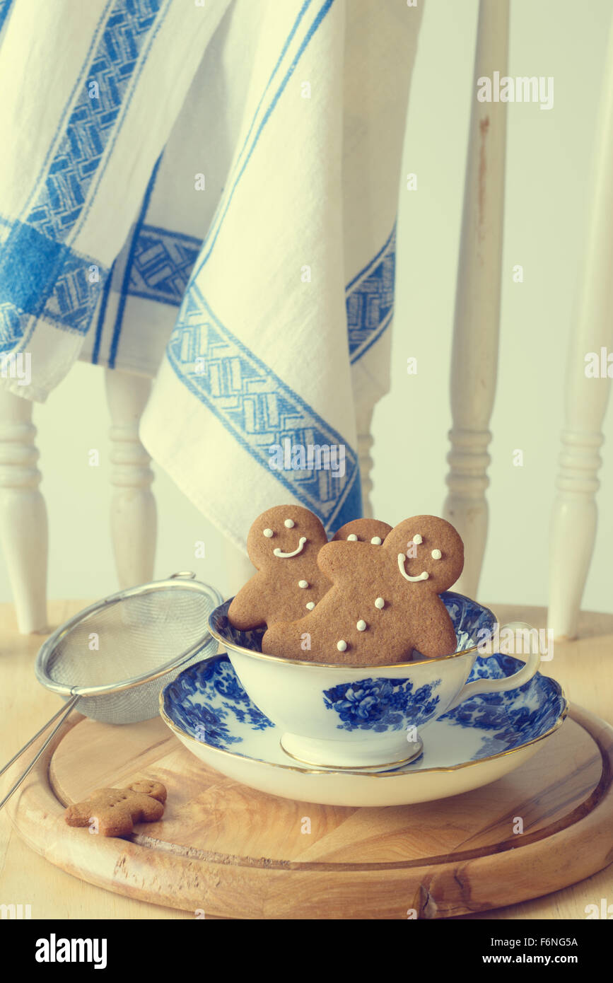 Homemade gingerbread men sitting in a vintage teacup Stock Photo