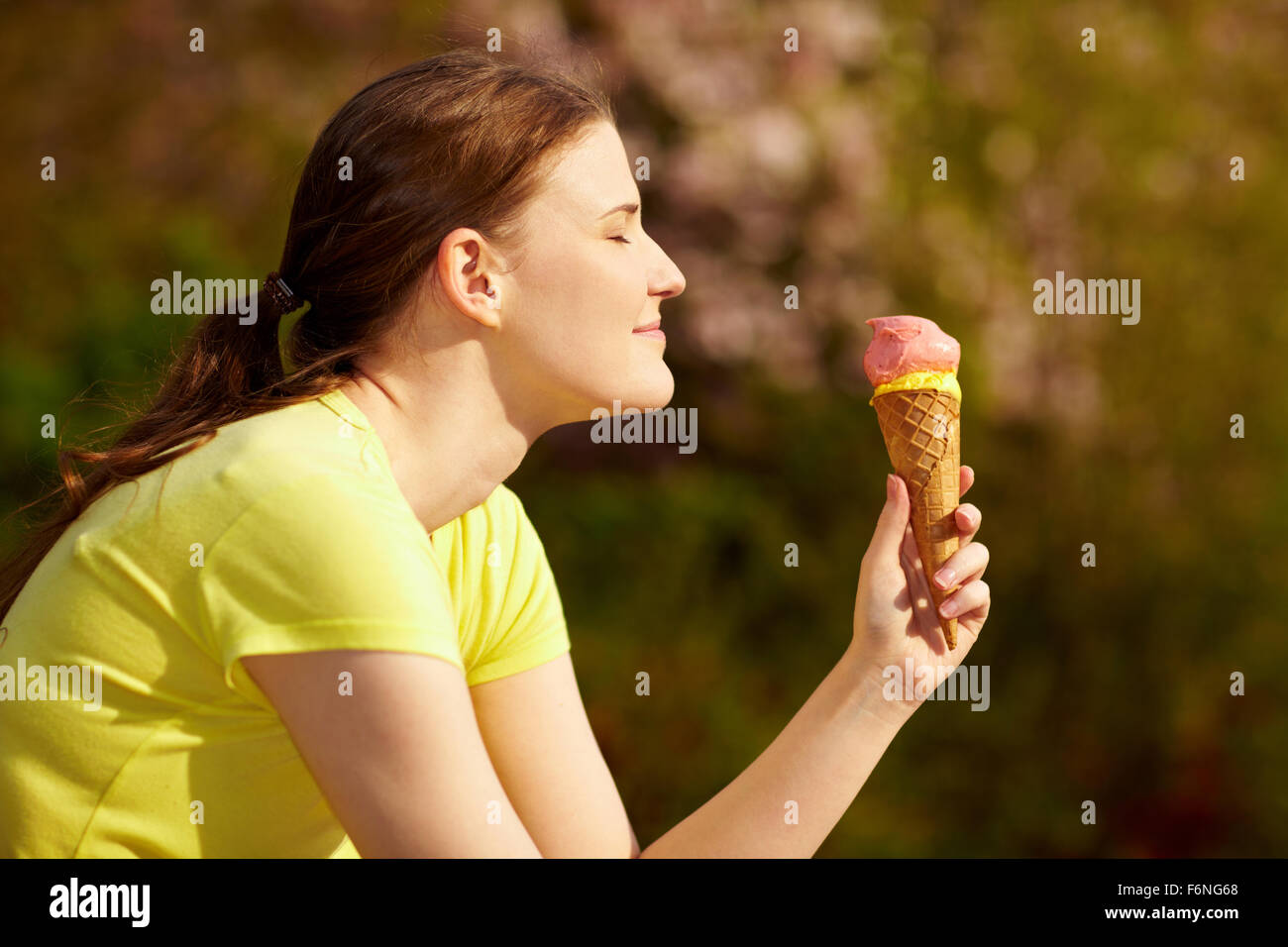 Happy woman eating an ice cream cone in summer Stock Photo