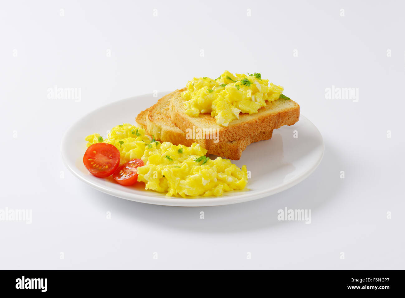 plate of scrambled eggs and slices of bread on white background Stock ...