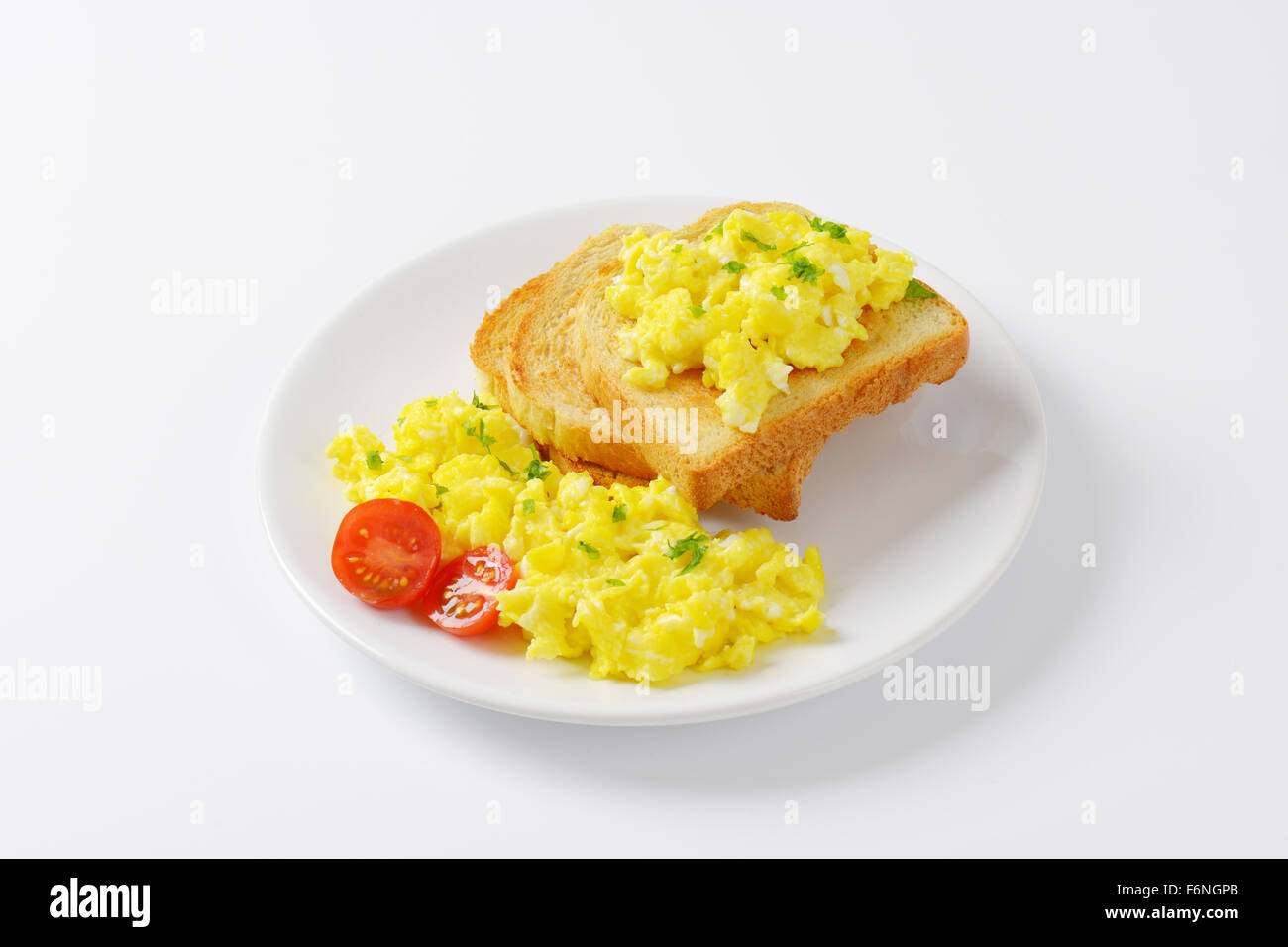 plate of scrambled eggs and slices of bread on white background Stock ...