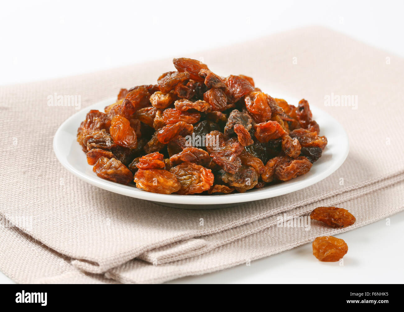 plate of raisins on beige place mat Stock Photo