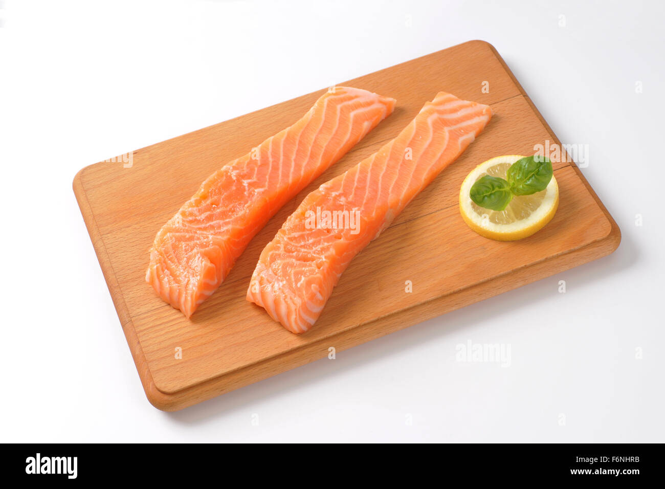 two raw salmon fillets on wooden cutting board Stock Photo - Alamy