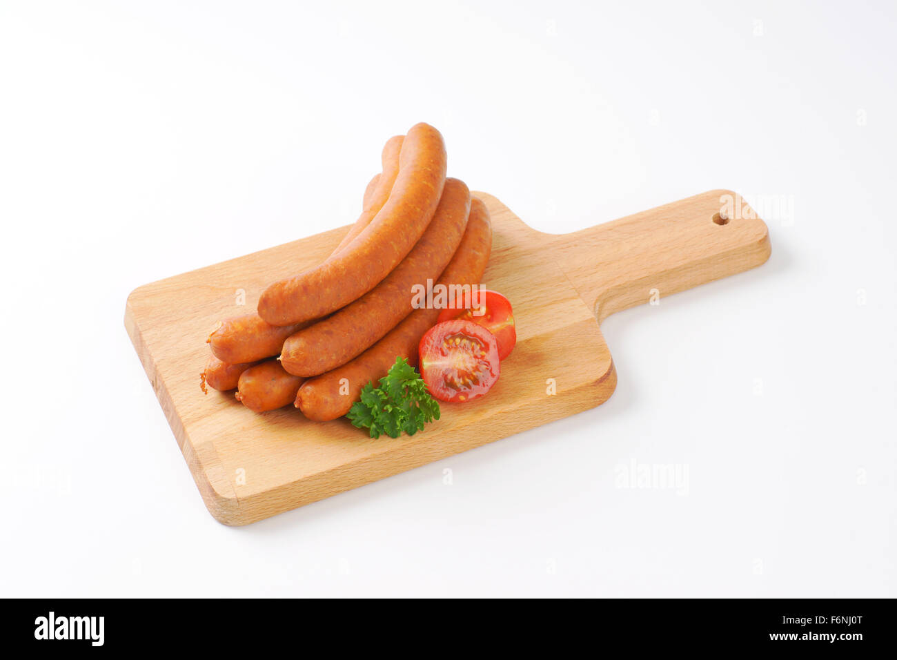 raw frankfurter sausages on wooden cutting board Stock Photo