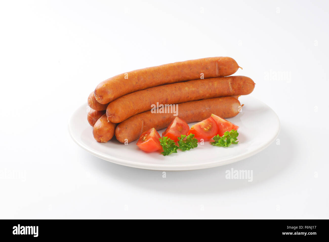 raw frankfurter sausages on white plate Stock Photo