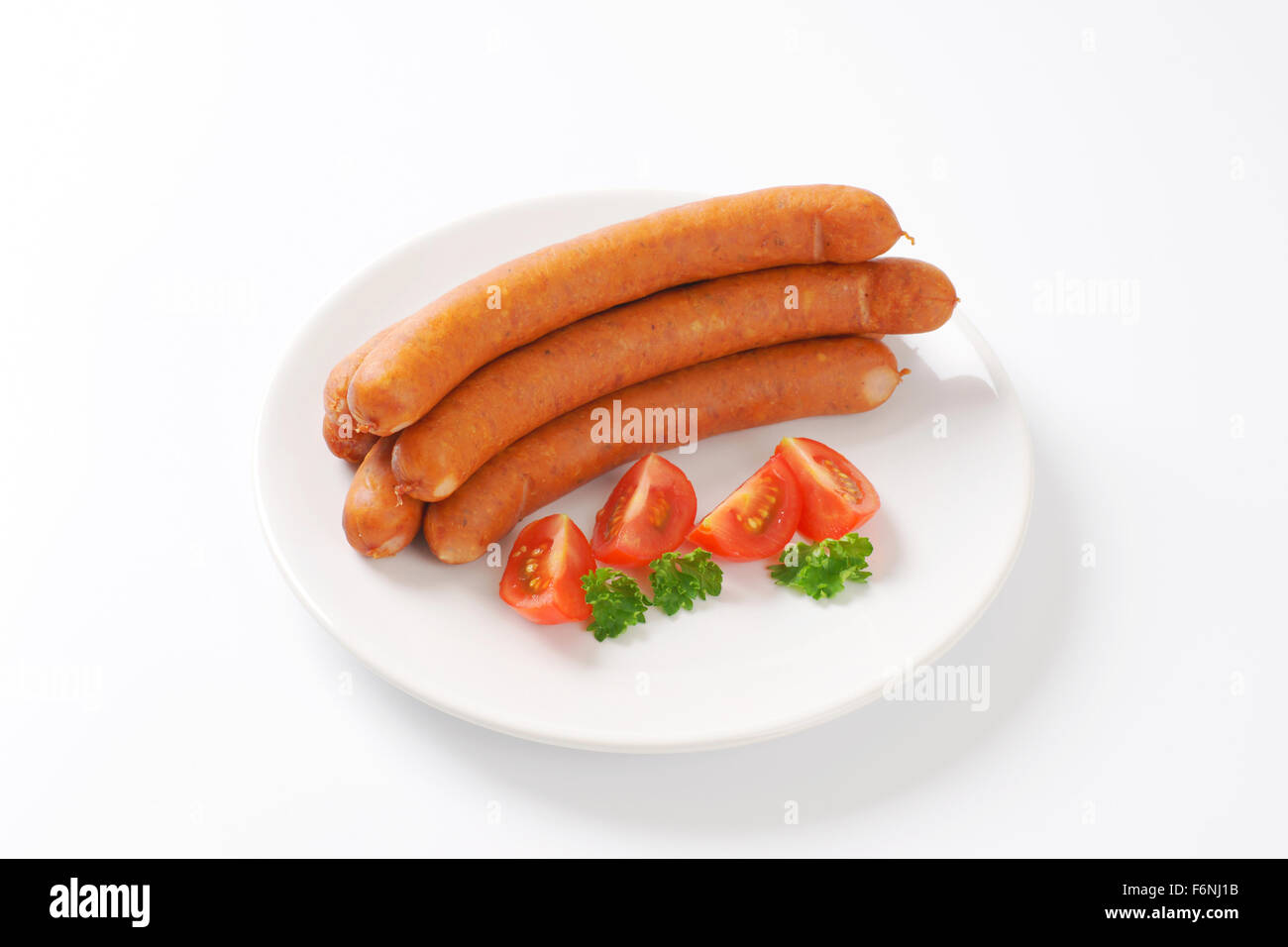 raw frankfurter sausages on white plate Stock Photo