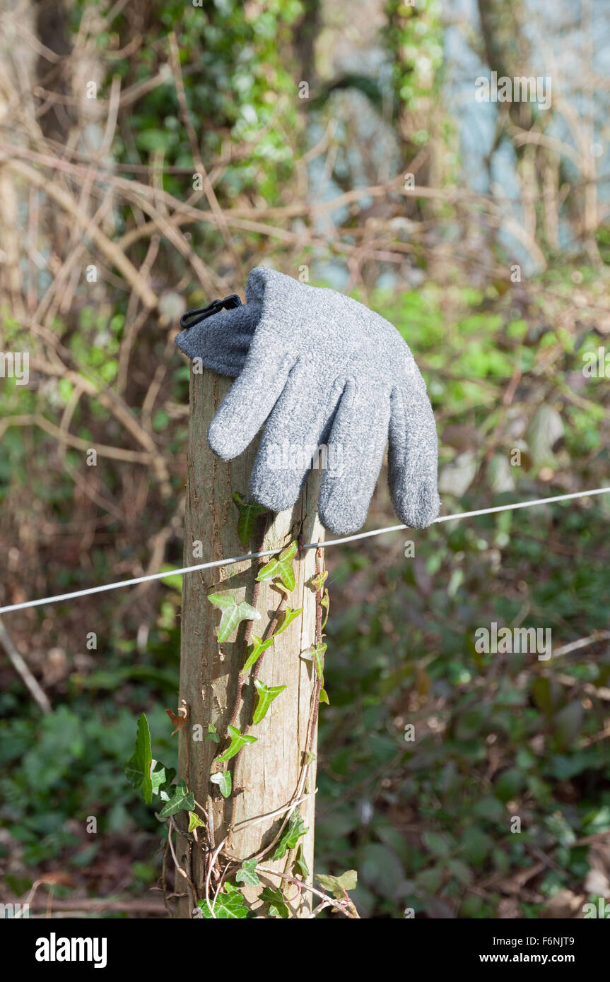 Lost grey glove found on fence-post country walk Stock Photo