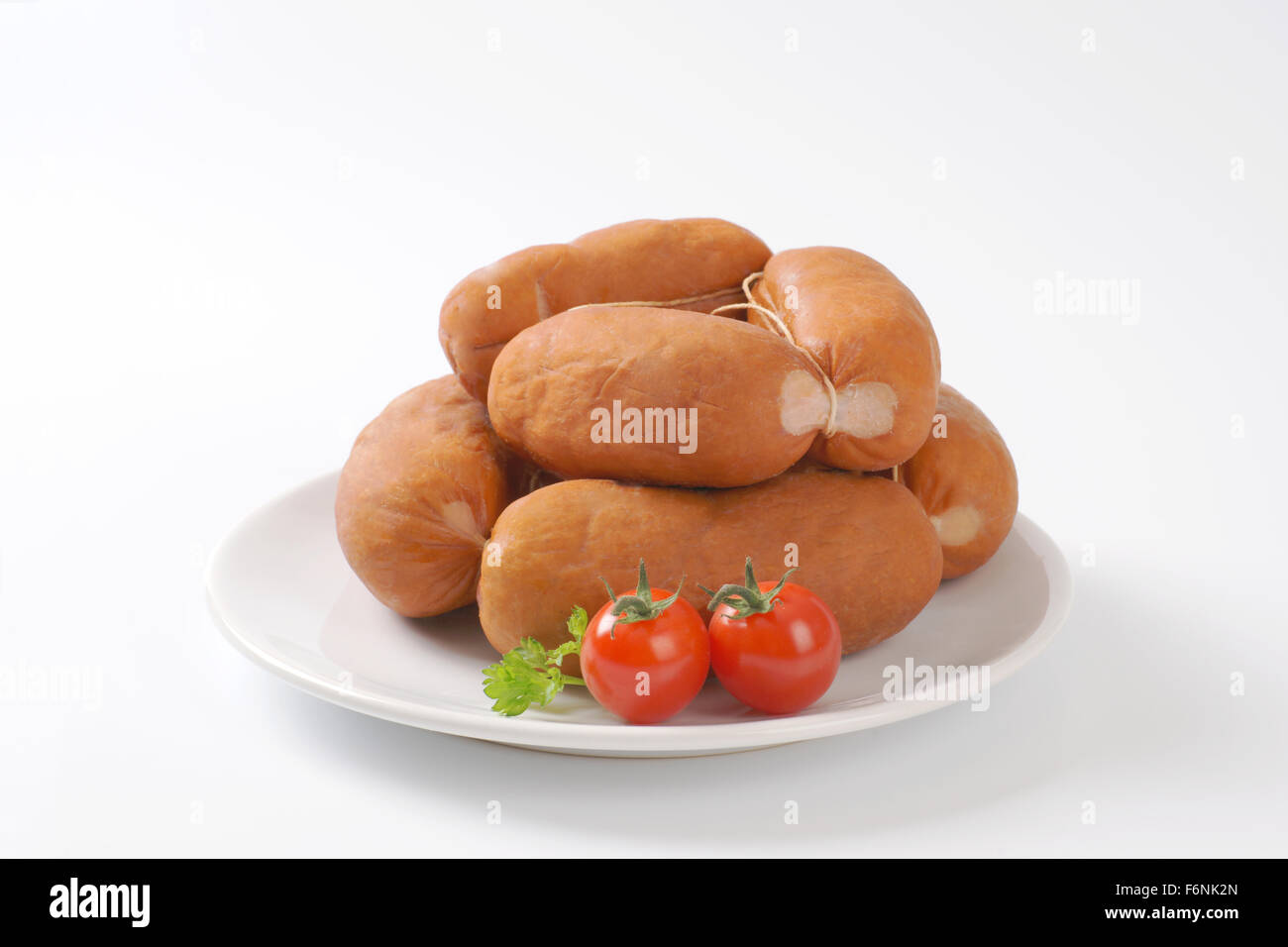 chain of raw wurst sausages on white plate Stock Photo