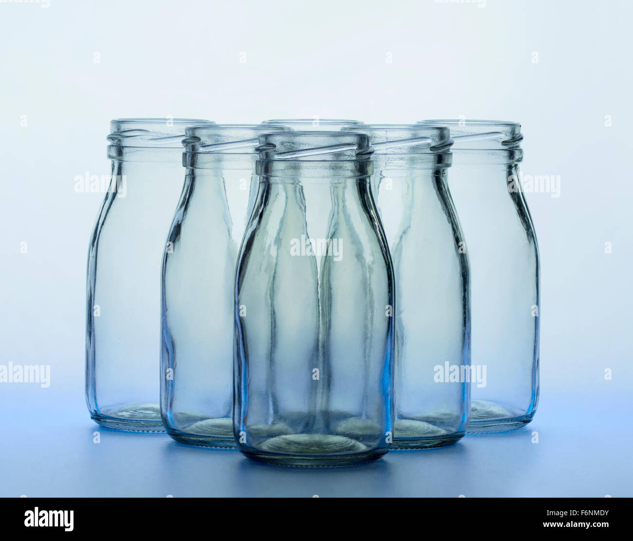 https://c8.alamy.com/comp/F6NMDY/blue-milk-bottles-6-standing-in-formation-recession-of-focus-triangular-F6NMDY.jpg