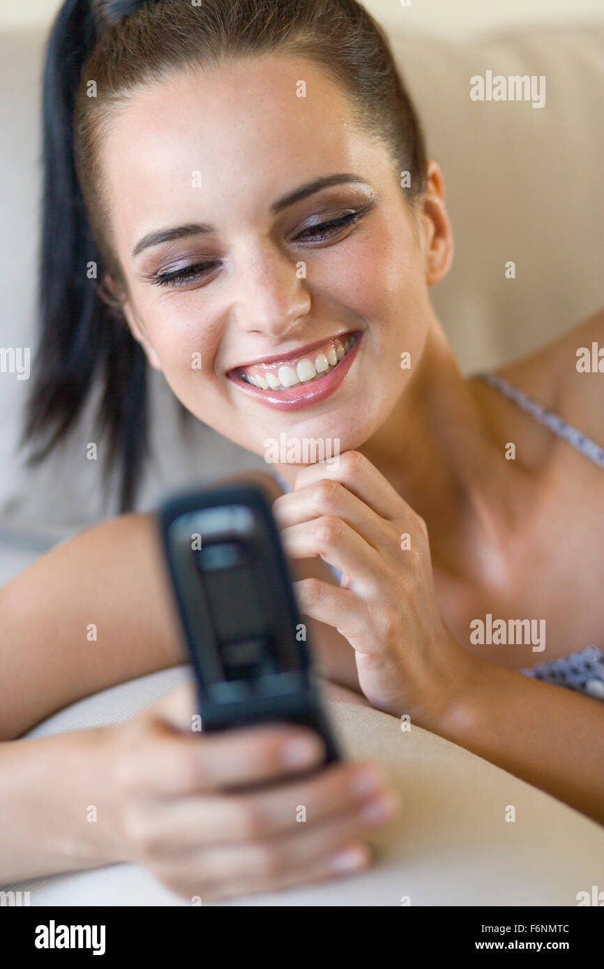 Young woman with cellphone on couch Stock Photo