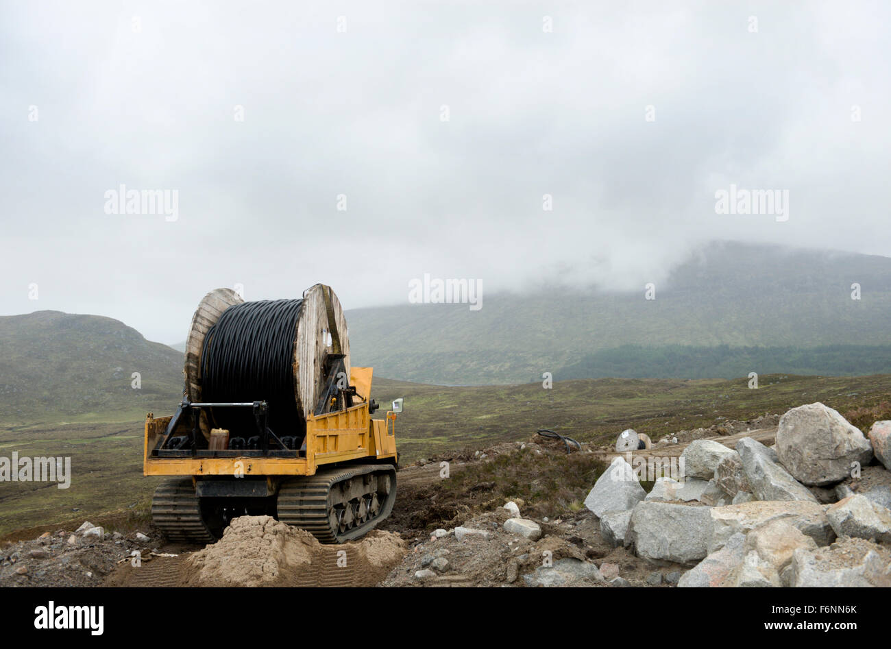 Installation of power supply cables over remote scottish hills Stock Photo