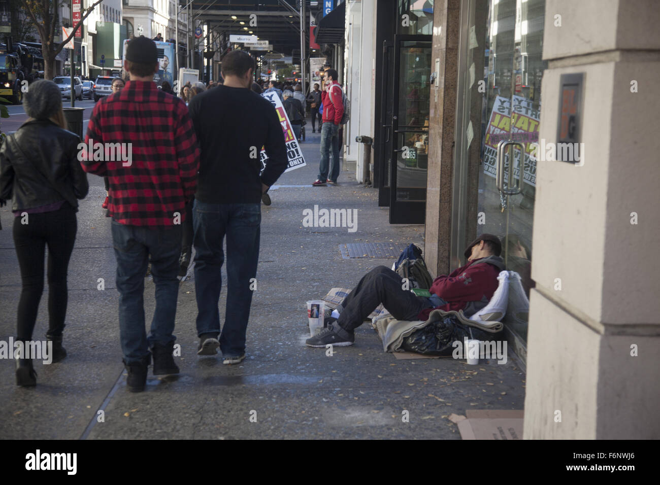Tired out man begs for money along 34th Street in New York City. Stock Photo