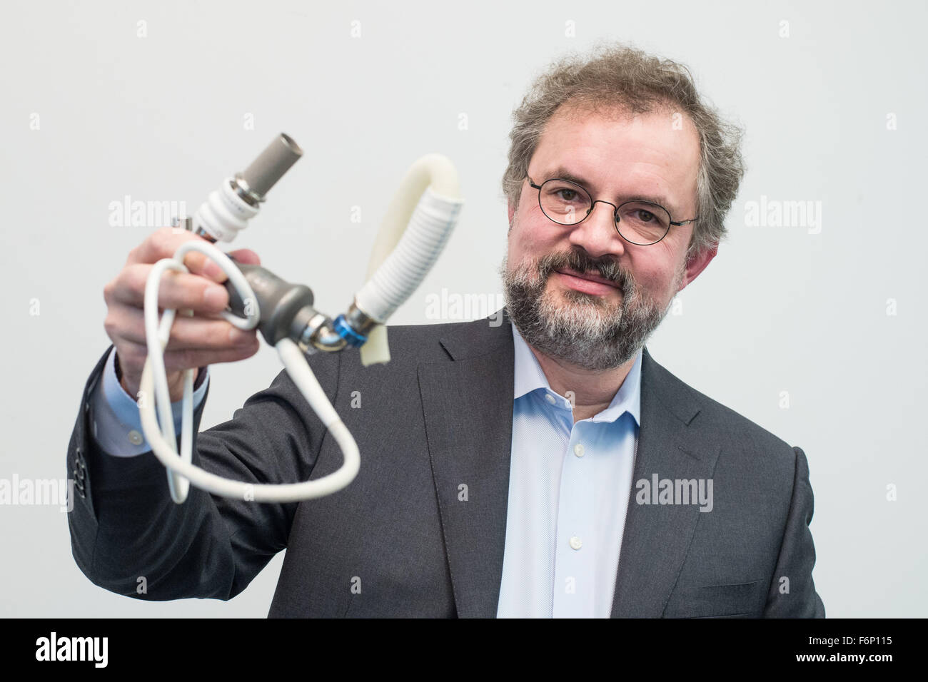 Martin Strueber from the Heart and Lung clinic at Michigan State University at a press conference in the Medical School (MHH) in Hannover (Lower Saxony), holding the ventricular assist device, 'HeartMate II' in his hand, Hannover, Germany, 18 November 2015. Strueber had installed the device inside patient Schulz in 2005 who has lived for ten years with the artificial heart, he is a according to the MHH the European record holder. Photo: OLE SPATA/dpa Stock Photo