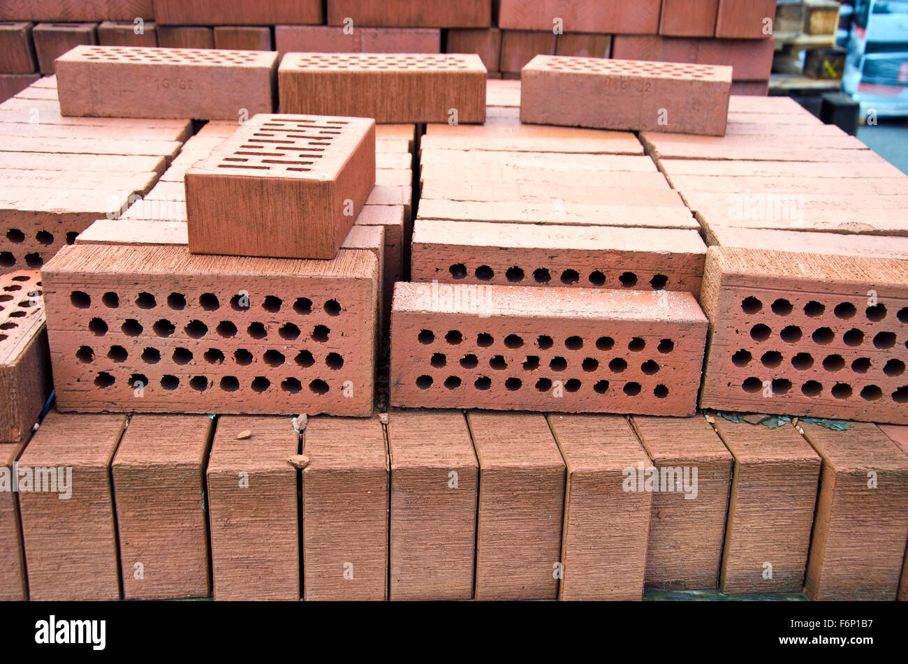 Stack of red clay bricks with holes in market Stock Photo