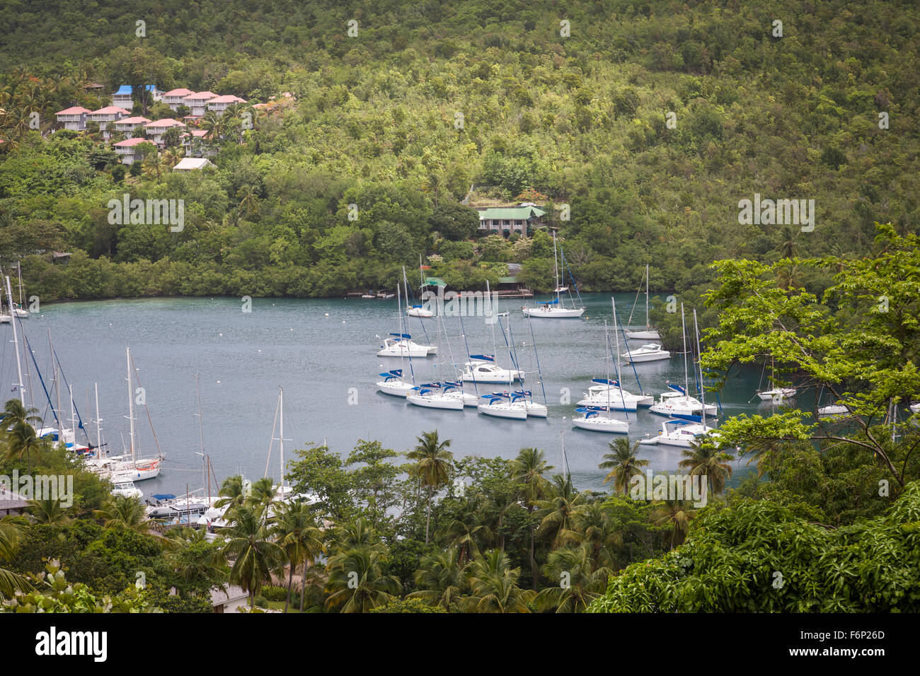 Mono hull yachts and catamarans lie at anchor within the sheltered ...