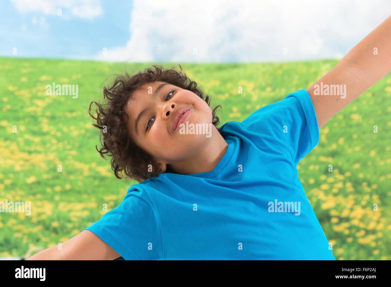 Happy laughing boy on green grass background Stock Photo