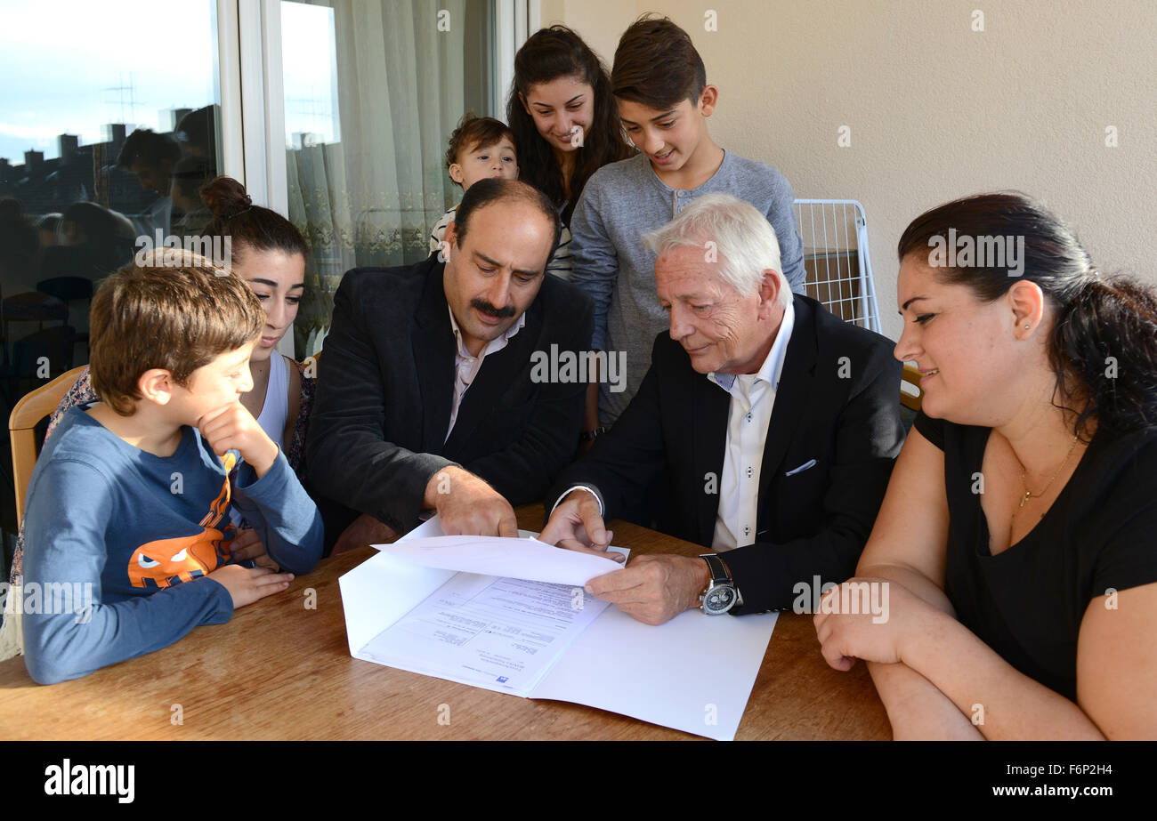 Paderborn, Germany. 16th Sep, 2015. The chairman of the local marksmenship association 'Paderborner Buergerschuetzen', Heinz-Josef Noetges (C) helps the Barsoum family from Syria reading through a document in Paderborn, Germany, 16 September 2015. Photo: Caroline Seidel/dpa/Alamy Live News Stock Photo