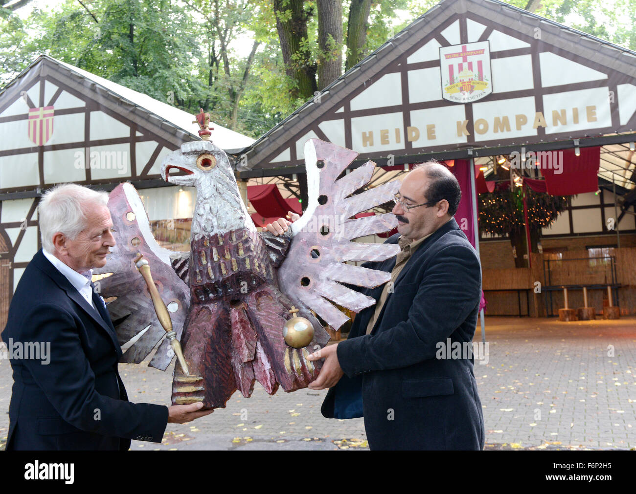 Paderborn, Germany. 16th Sep, 2015. The chairman of the local marksmenship association 'Paderborner Buergerschuetzen', Heinz-Josef Noetges (l) and Gabro Barsoum (r) from Syria carry a marksmenship eagle to the festival tent of the association in Paderborn, Germany, 16 September 2015. Photo: Caroline Seidel/dpa/Alamy Live News Stock Photo