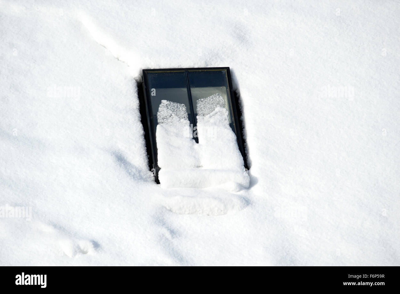 Conservation style velux window on the roof of a converted steading in Scotland, almost covered in snow Stock Photo