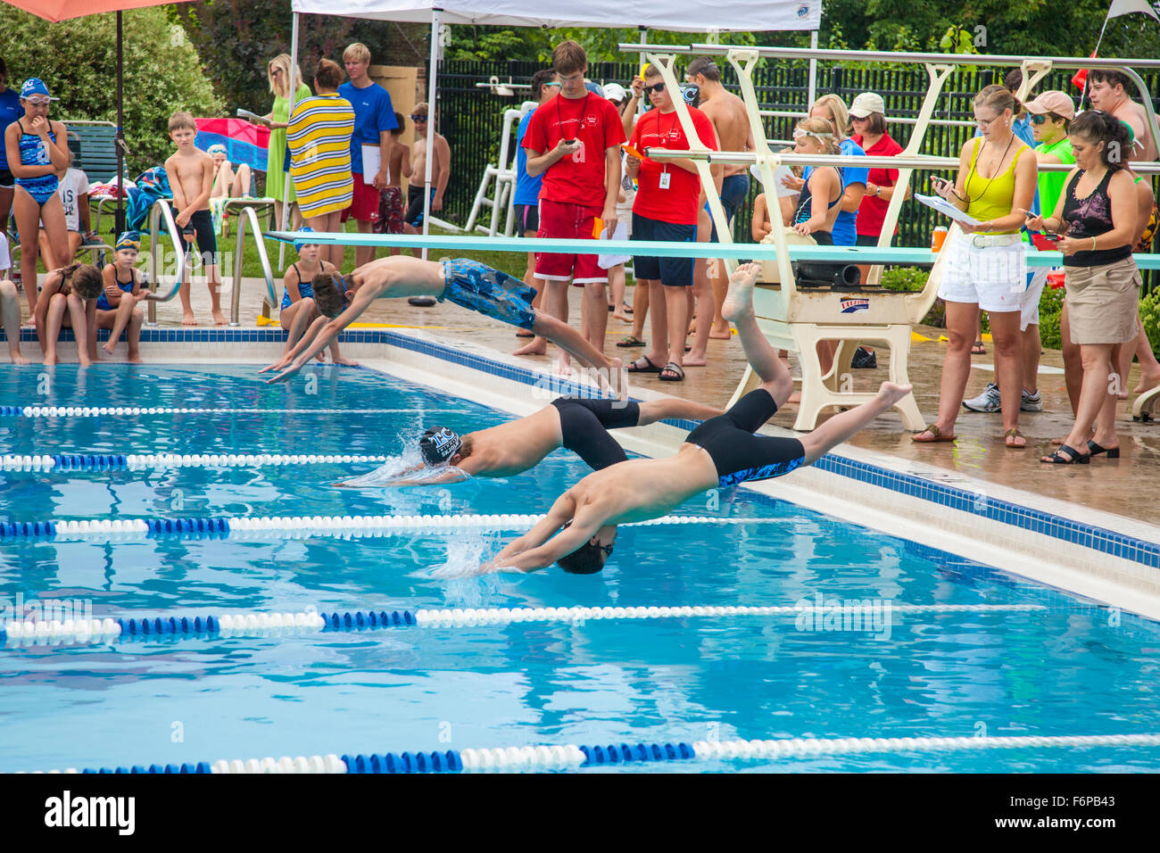 Boys age 12 diving into pool water participating in swim meet. St Paul