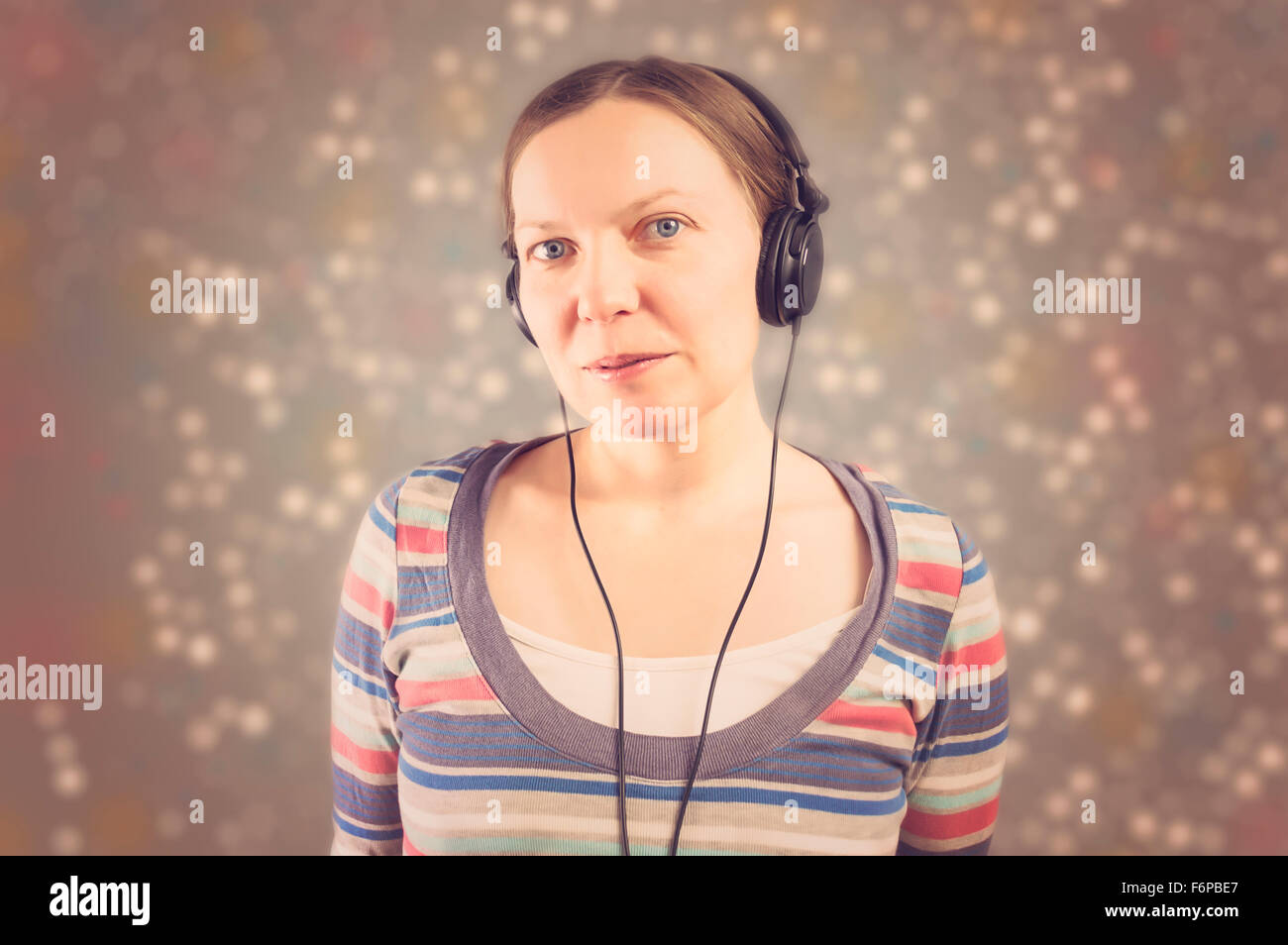 Portrait of a beautiful woman with headphones listening to music. Selective focus. Stock Photo