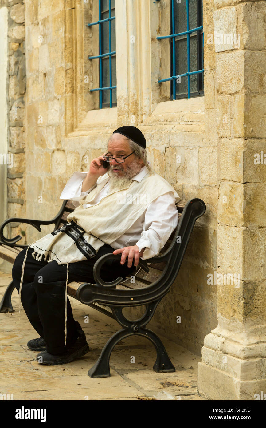 a-jewish-man-talking-on-his-cell-phone-outside-a-synagogue-in-safed-F6PBND.jpg