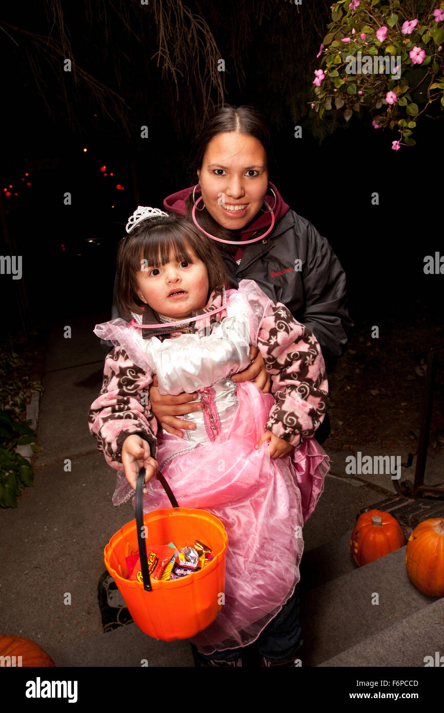 Hispanic mom presenting her tiara crowned costumed daughter for