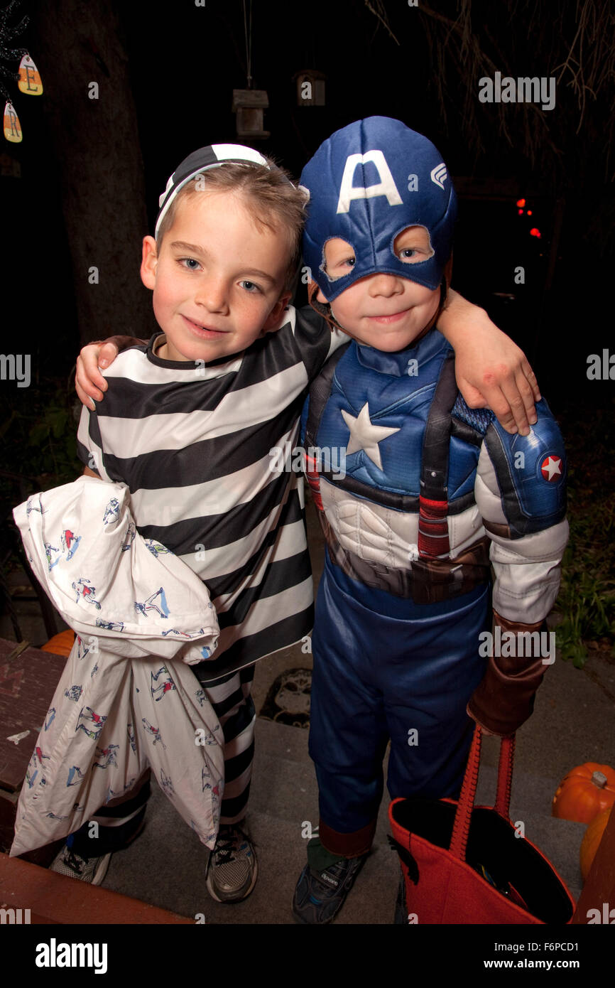 Captain America and prisoner in stripped costume out for a night of Halloween trick or treating. St Paul Minnesota MN USA Stock Photo