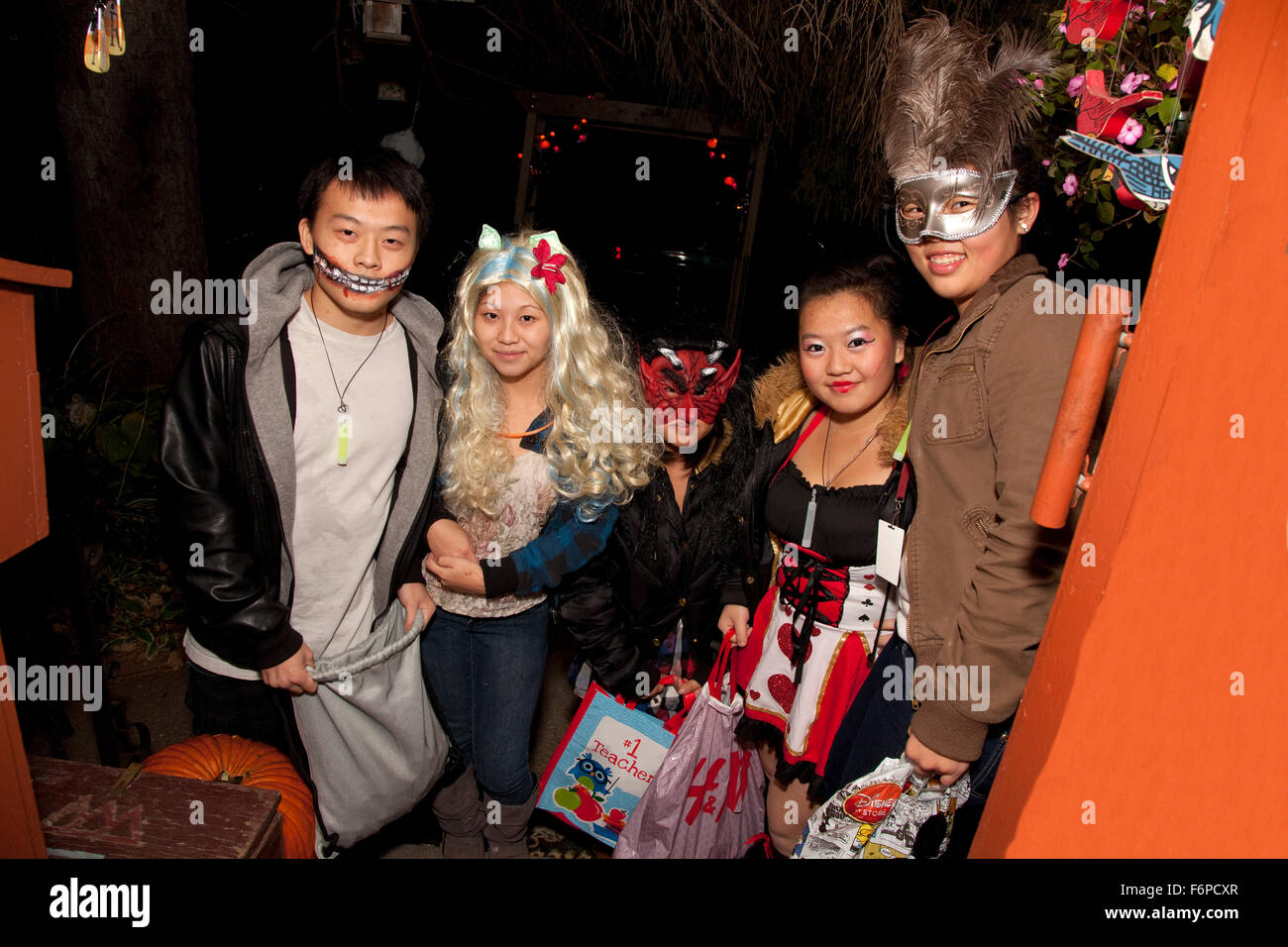 Halloween costumed Asian American teens trick or treating. St Paul